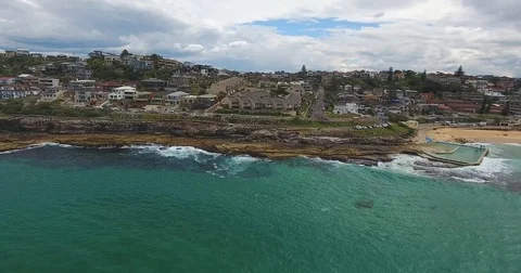 Waves hit rock cliffs with private houses on top Stock Footage 70825858