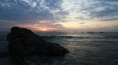 Waves hit rock at sunrise static Stock Footage 29908704