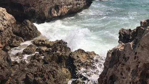 Waves Hit a Rocky Landscape Видео 95035636