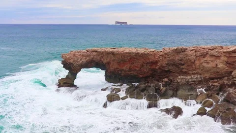 Waves hit stone arch, the beautiful natural rock formations at Malta's island Stock Footage 99685910