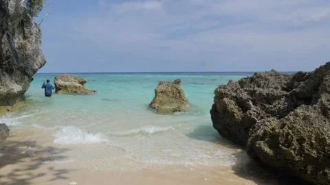 The waves hit the waves in the cracks of the rocks and surged on the beach. A Stock Footage 130903170