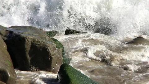 Waves hiting stones slow motion Stock Footage 75982699