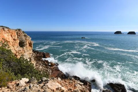 Waves hitting the base of the cliffs on the western Algarve in Portugal Stock Photos