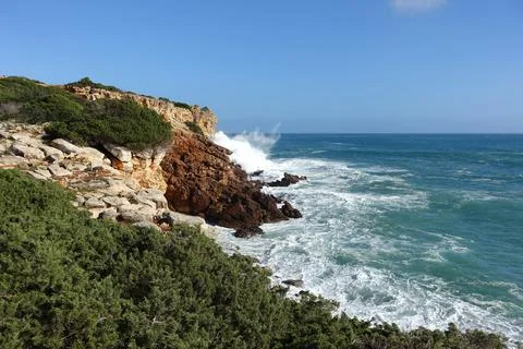 Waves hitting the base of the cliffs in the western algarve, Portugal Stock Photos