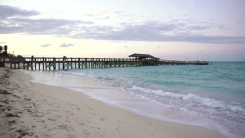 Waves hitting a beach in the Bahamas at Sunset Видео 133806402