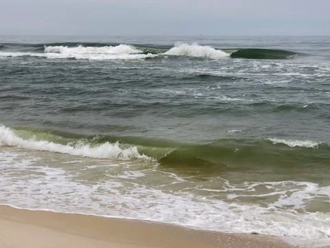 Waves on hitting the beach Stock Photos