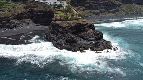 Waves hitting the cliff surrounded by black sand beaches Stock Footage 205523213