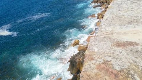 Waves hitting cliffs, revealing the city, at Coogee beach, on a sunny summer  Stock Footage 86043459