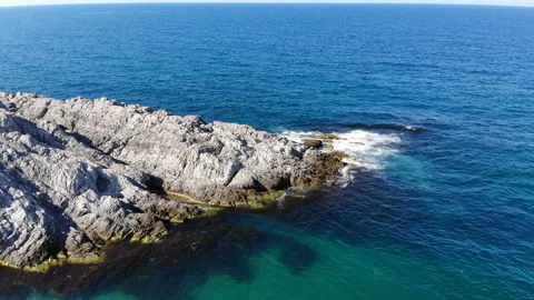 Waves hitting the cliffs on the rocky coast of the sea. Cliffs of blue sea. Stock Footage 139840553