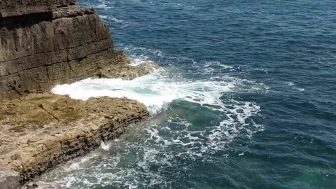 Waves hitting rock cliff with horizontal bedding in Dorset in southwest Engla Stock Footage 158478773