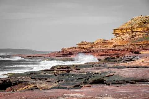 Waves hitting rock coast with different colors from red to yellow in the Kalb Stock Photos