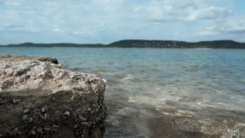 Waves hitting rock at lake Stock Footage 157283854