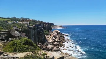 Waves hitting rocks and cliffs, at the coast of  Coogee beach, on a sunny sum Stock Footage 86043776
