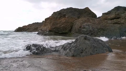 Waves hitting the rocks on the beach Stock Footage 131837688