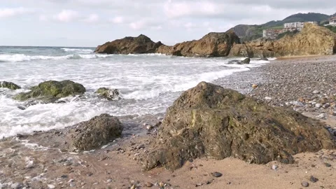 Waves hitting the rocks on the beach Stock Footage 131838167