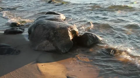 Waves hitting rocks on beach at sunset  close up 動画素材 955142
