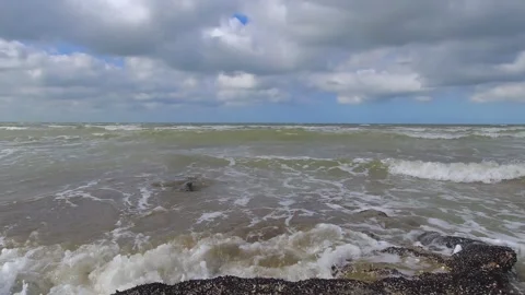 Waves hitting rocks covered in mollusks on the shoreline of a beach. Blue s.. Stock Footage 286764342