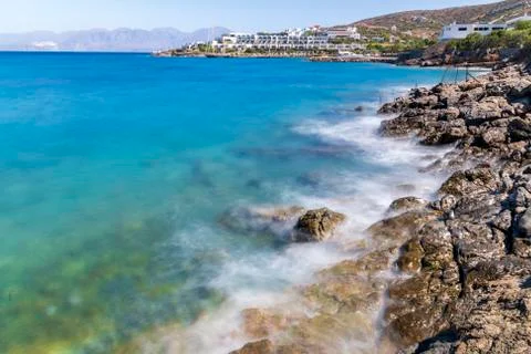 Waves hitting the rocks during hot summer day in Greece Stock Photos