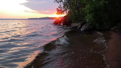 Waves hitting rocks during sunset Video stock 134657179