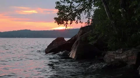 Waves hitting rocks on shore during sunset Stock-Footage 134657181