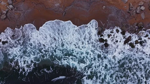 Waves hitting rocks on a shoreline during the day Vídeos de archivo 331296287