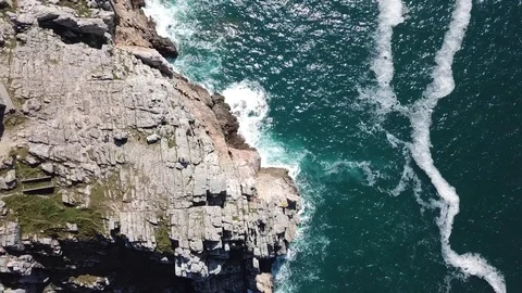 Waves hitting rocks on the steep coast. Aerial drone shot. Stock Footage 128373889