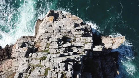 Waves hitting rocks on the steep coast. Aerial drone shot top view. Stock Footage 128376786