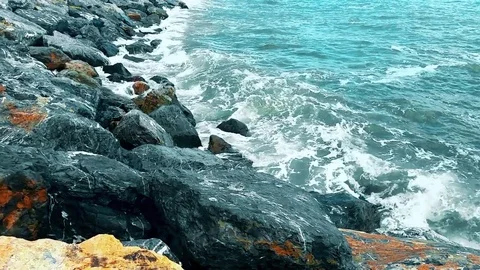 Waves hitting the rocks on a sunny day Stock Footage 78973976