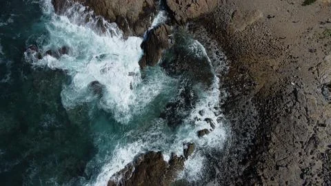Waves hitting the rocks view from above Stock Photos