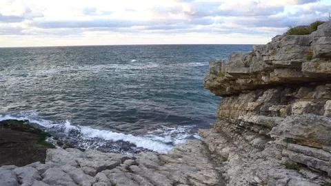 Waves hitting rocky cliff Stock Footage 95977925