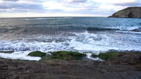 Waves hitting rocky cliff Stock Footage 95978377