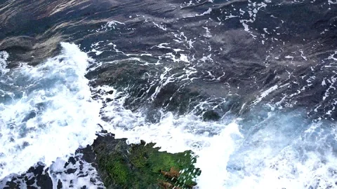 Waves hitting rocky cliff Stock Footage 95979654