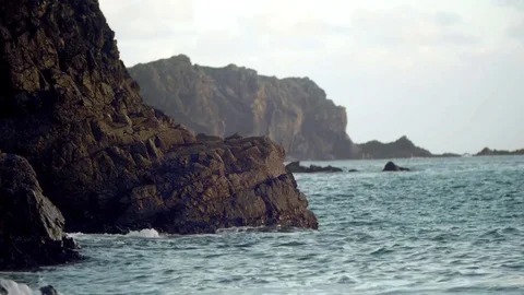 Waves hitting rocky cliffs. Locked down shot evening sun mood. Stock Footage 71293275