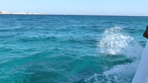 Waves hitting the side of a boat on the light blue sea Stock Footage 141524741