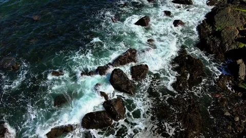 Waves hitting wave beaten rocks along coastal edge. Sea striking surf washed Stock Footage 328358379
