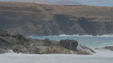  the waves hurl themselves against the cliff on a cloudy day- slow motion Stock Footage 67491369