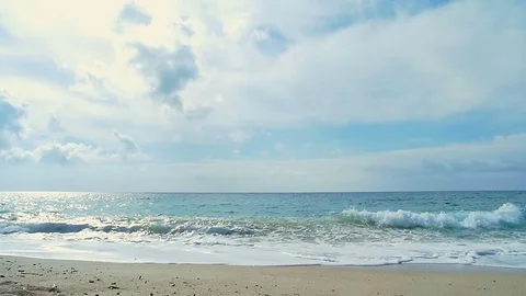 Waves landing on sandy beach. Clear blue water. Slow motion. Stock Footage 82407502