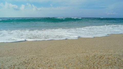 Waves landing on sandy beach. Clear blue water. Slow motion. Video stock 82633634