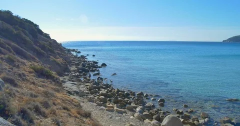 Waves landing on stone beach. Clear blue water. Stock Footage 82283123