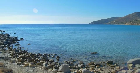Waves landing on stone beach. Clear blue water. Stock Footage 82324405