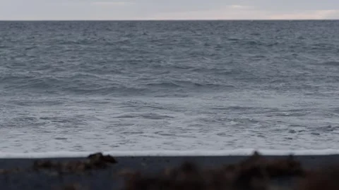 Waves lap against the shore at serene beach during afternoon, calming atmosphere Stock Footage 318108686