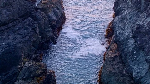 Waves lap between rocks at sunset from cliff Oregon Coast Stock Footage 81948002