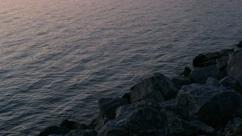Waves Lap Gently Against Rocks In A Lake Stock Footage 87396700