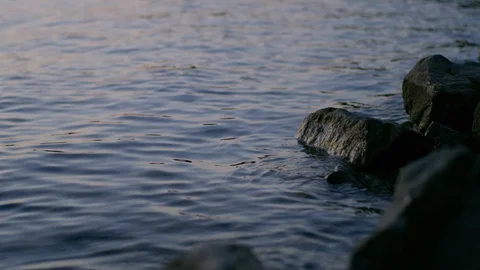 Waves Lap Gently Against Rocks In A Lake Stock Footage 87396812