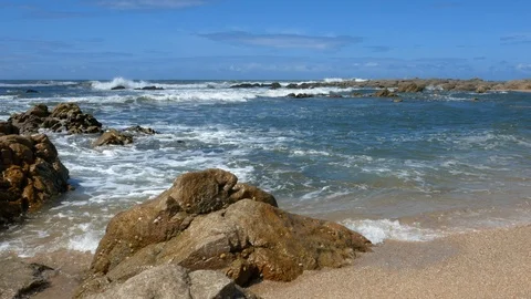 Waves lap on the shore at beach with rock in foreground. Slider shot. 스톡 동영상 108194584