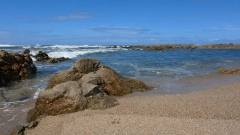 Waves lap on the shore at beach with rocks in foreground. Stock Footage 108193800
