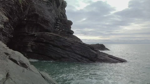 Waves lapping against cliffs at the edge of the ocean in Liguria Stock Footage 176492019