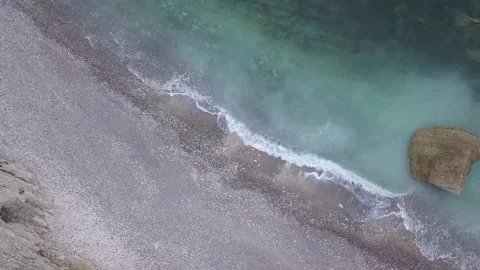 Waves lapping against a shingle beach as viewed from overhead 스톡 동영상 141664776