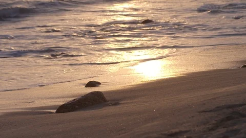 Waves lapping on the beach at sunset Stock Footage 105852125