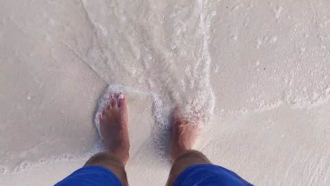 Waves lapping over mans feet Stock Footage 146388028